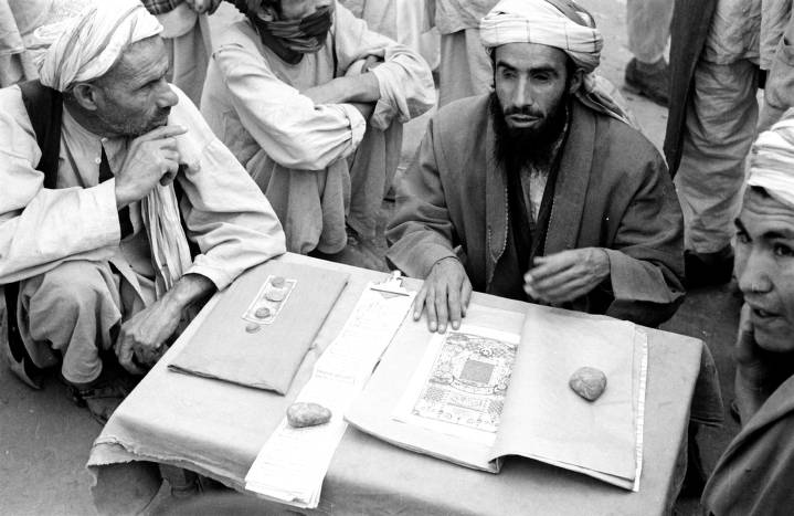 Harrison Forman (US), Afghanistan, men surrounding storyteller in K abul market, 1953.